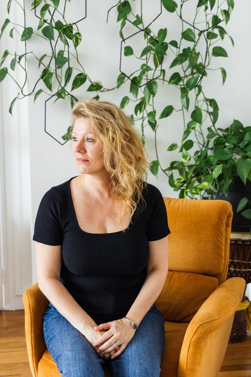 Delphine Delcroy assise dans un fauteuil, près d’un feuillage